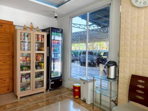 a kitchen with a large refrigerator and a window at Veerakit Grand Hotel Udon Thani in Udon Thani