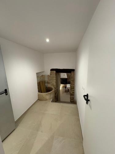 a hallway with white walls and a stone wall at Casa Brillantes Completa in Ayerbe