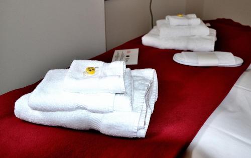 three white towels are sitting on a red table at Boutique Hotel Fusio in Fusio