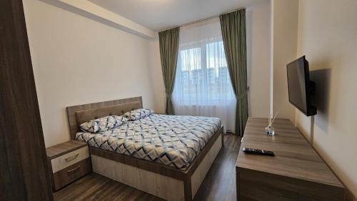 a small bedroom with a bed and a television at Rădăuți Residence in Rădăuţi