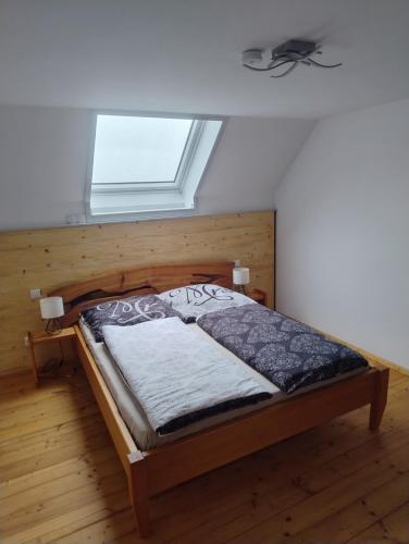ein Schlafzimmer mit einem Holzbett und einem Fenster in der Unterkunft Spehnerhof in Vogt