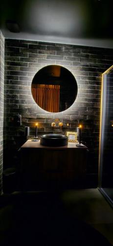 a bathroom with a sink and a large mirror at VILLA CLOSE BRIVE centre - LOVE ROOM - SPA privatif in Brive-la-Gaillarde