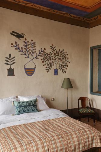 a bedroom with a bed with plants on the wall at Beit Felfel in Esna