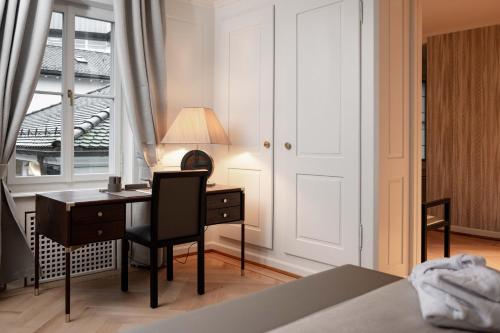 a bedroom with a desk and a chair and a lamp at MEWS House Zürich in Zurich