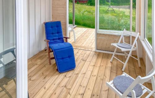 a blue suitcase sitting on a porch with chairs at Amazing Home In Burseryd With Kitchen in Burseryd