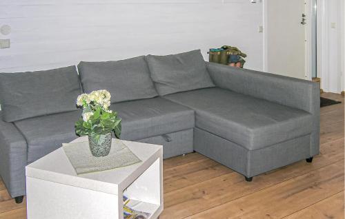 a gray couch in a living room with a table at Amazing Home In Burseryd With Kitchen in Burseryd