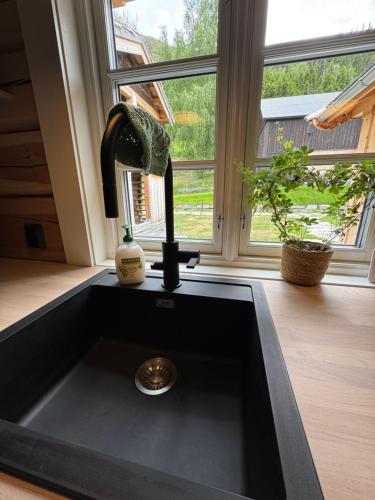 a kitchen sink with a faucet in front of a window at Gunhild-stugu in Skogbygd