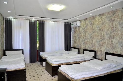 a room with three beds in a room with a wall at Uhum Mountain Guesthouse in Yukary-Ukhum