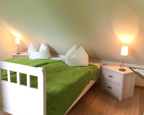 a bedroom with a bed with white pillows and two tables at Nixe in Timmendorf
