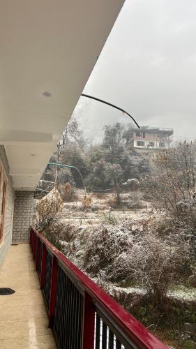 a view of a snowy field from a balcony at Nomaden Kasol in Kasol