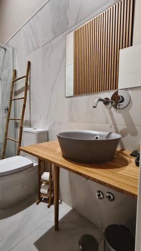 a bathroom with a black bowl sink on a wooden counter at Temple Suites Guesthouse in Portimão