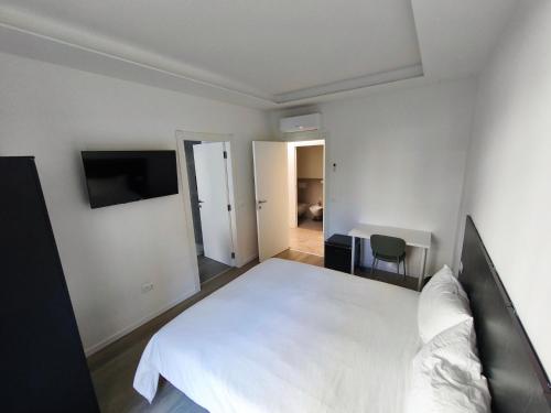 a bedroom with a white bed and a desk at Grace House in Padova