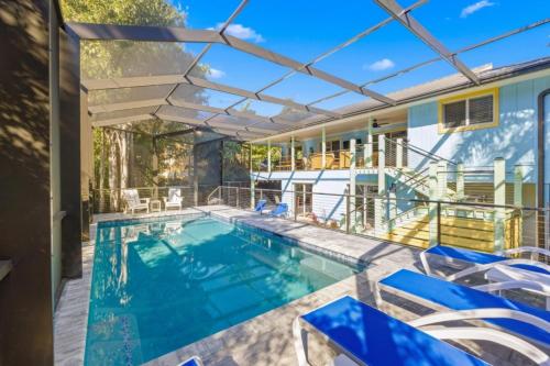 an indoor swimming pool with blue chairs and an umbrella at Dancing Dolphin in Captiva