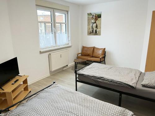 a room with two beds and a chair and a window at Monteurwohnung in Coswig in Coswig