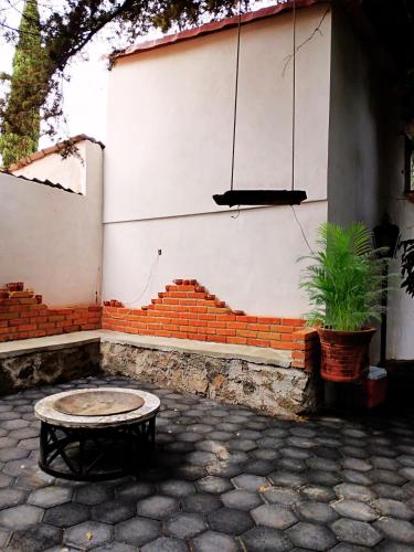 a bench sitting in front of a wall with a piano at Casa de Campo Huasca - Centro in Huasca de Ocampo