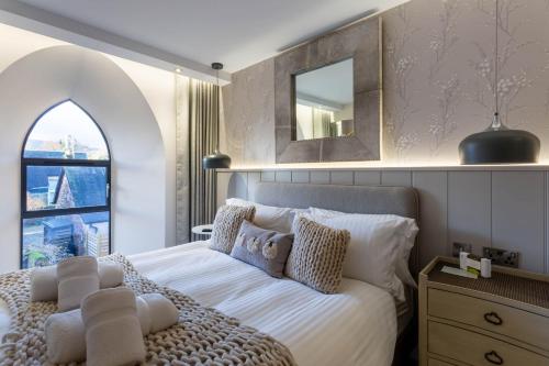 a bedroom with a bed with a mirror and a window at Arran Shores Luxury Shorefront Apartment 2 in Lamlash
