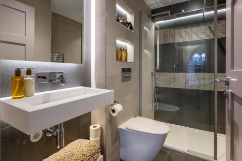 a bathroom with a sink and a toilet and a shower at Arran Shores Luxury Shorefront Apartment 2 in Lamlash