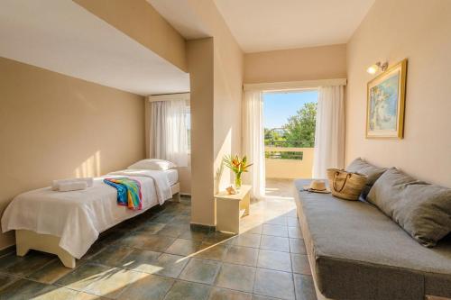 a living room with two beds and a couch at Ilios Mare Hotel in Agia Marina Nea Kydonias