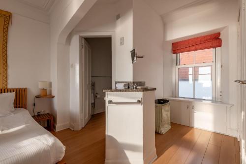 a white room with a bed and a white refrigerator at Appleton House - Lower Largo in Lower Largo
