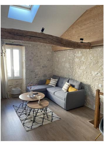 a living room with a couch and a table at La Pierre Pourpre in Eymet