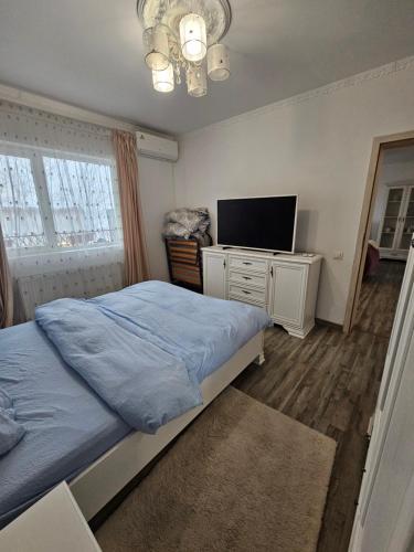 a bedroom with a bed and a flat screen tv at Rowlands Way 1 in Ţegheş