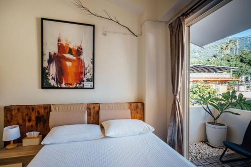 a bedroom with a bed and a painting on the wall at Vuluq in Shoufeng