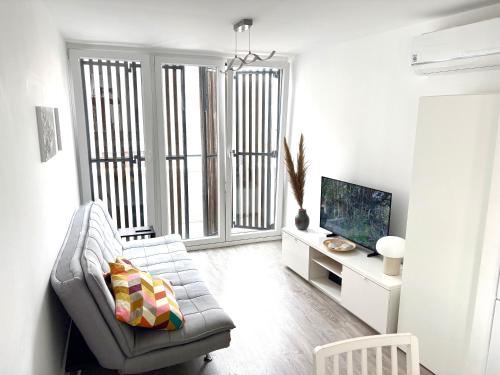 a living room with a couch and a tv at Casa Luminosa - 160m to the beach, located in the Historical Center of Sesimbra in Sesimbra