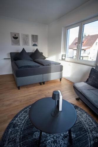 a living room with a bed and a table and a couch at JS-Business in Balingen