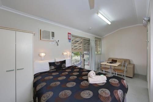 a bedroom with a large bed and a table at Dalby Tourist Park in Dalby