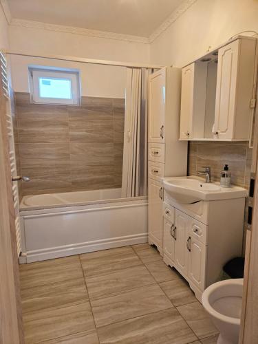a bathroom with a tub and a sink and a toilet at Rowlands Way 3 in Ţegheş