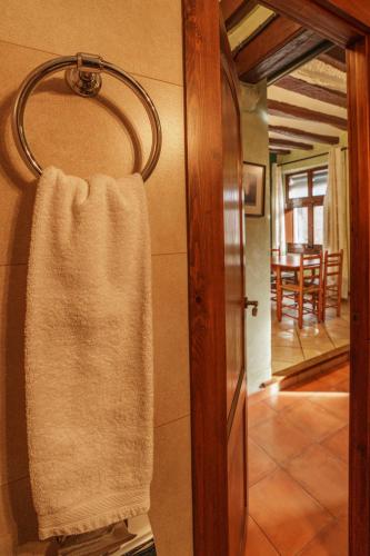 a towel hanging on a wall next to a mirror at Allotjaments Plaça Major-Aulina in Santa Pau
