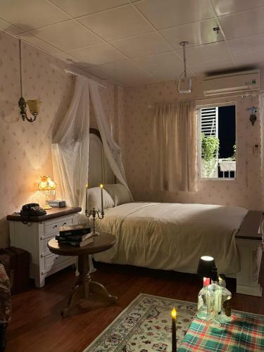 a bedroom with a bed and a table and a window at 221B Baker in Ấp Phú Thọ