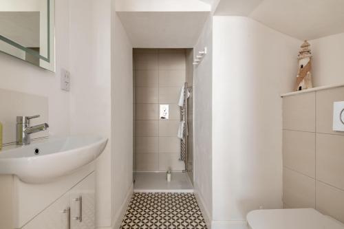 a white bathroom with a sink and a toilet at School Wynd No 6 - Elie in Elie