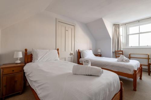 a bedroom with two beds with white sheets and a window at School Wynd No 6 - Elie in Elie