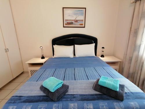 a bedroom with a blue bed with two pillows at Rosscarbery 6 in Margate