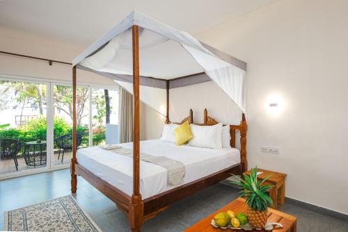 a bedroom with a bed with a canopy at Tanzanite Beach Resort and Spa in Nungwi