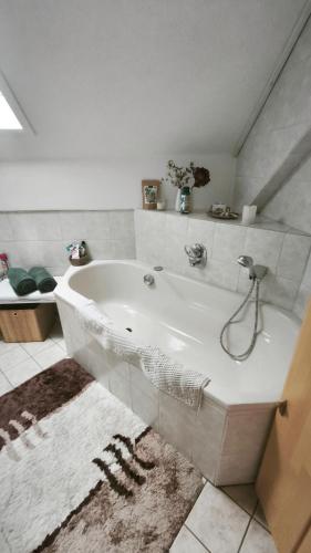 a white bath tub in a bathroom with a rug at Gästewohnung Urfttalsperre in Schleiden