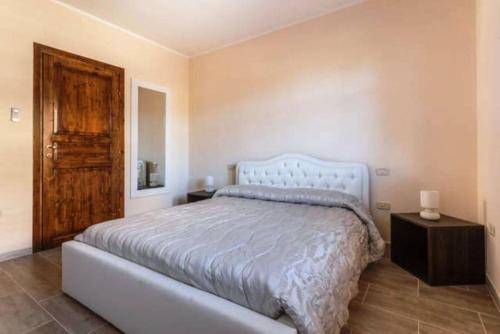 a bedroom with a bed and a wooden door at AnaeleHouseapartments LTB in Arborea