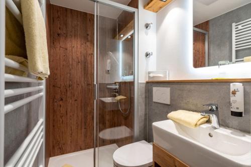 a bathroom with a toilet and a sink and a shower at Hotel Restaurant Frühlingsgarten in Füssen