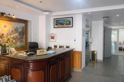 a reception desk in a room with a painting on the wall at Anh Đào 2 Hotel in Hai Phong