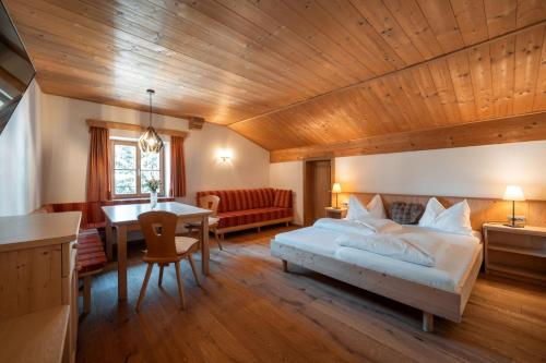 a bedroom with a bed and a dining room at Garni Tschutscherhof in Laion