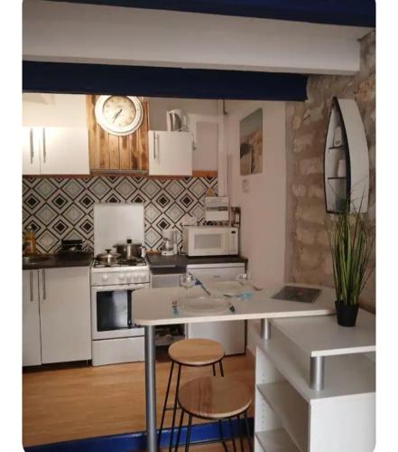 a kitchen with white appliances and a counter top at Studio cocooning entre Fouras et Rochefort in Saint-Laurent-de-la-Prée