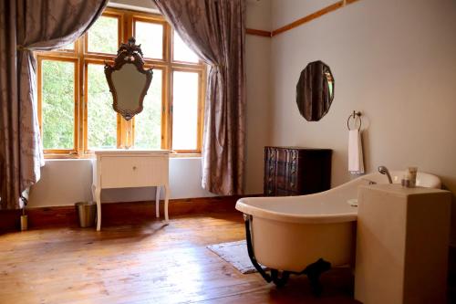 a bathroom with a bath tub and a window at The Dullstroom Inn in Dullstroom