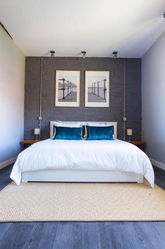 ein Schlafzimmer mit einem großen weißen Bett und blauen Kissen in der Unterkunft Arbide Suite in Leioa