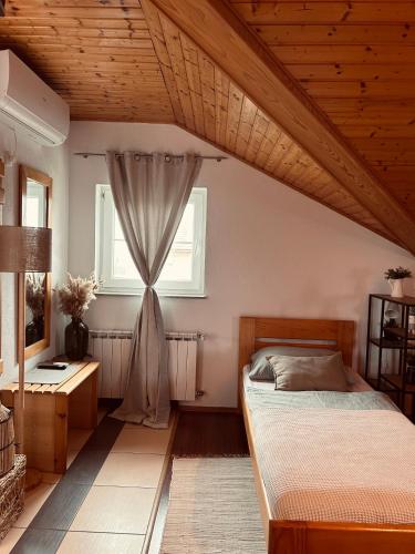 a bedroom with a bed and a window at Studio Apartment Žafran in Smoljanac