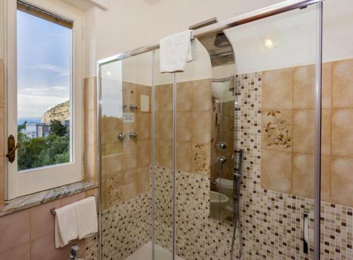 a bathroom with a shower with a glass door at Sisters Hotel in Piano di Sorrento