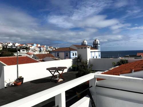 a balcony with a view of the ocean and buildings at City Center Apartment in Angra do Heroísmo