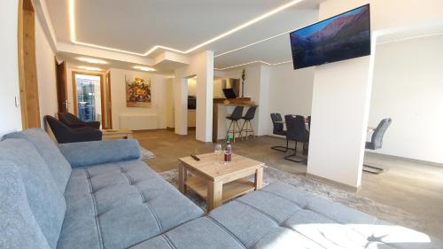 a living room with a blue couch and a table at Luxus Terrassenappartement Berg & See 1 in Bodensdorf