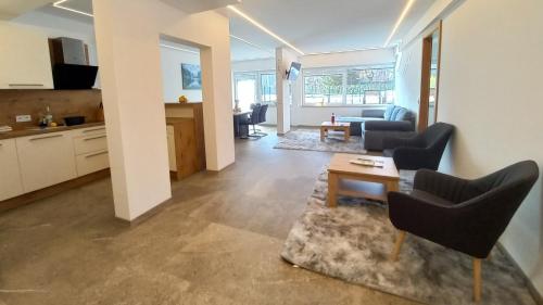 a living room with couches and a table and a kitchen at Luxus Terrassenappartement Berg & See 1 in Bodensdorf
