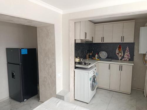 a kitchen with a refrigerator and a washing machine at Jermuk Calm House in Jermuk